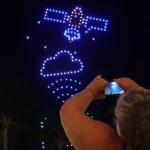 Persona tomando una foto al show de drones del cielo