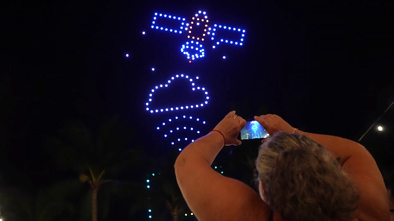 Persona tomando una foto al show de drones del cielo