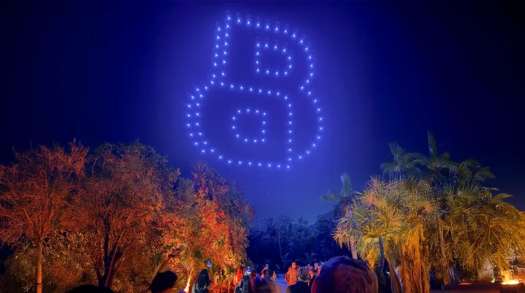 Drones haciendo logo de Boss en el cielo con público