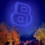 Drones haciendo logo de Boss en el cielo con público