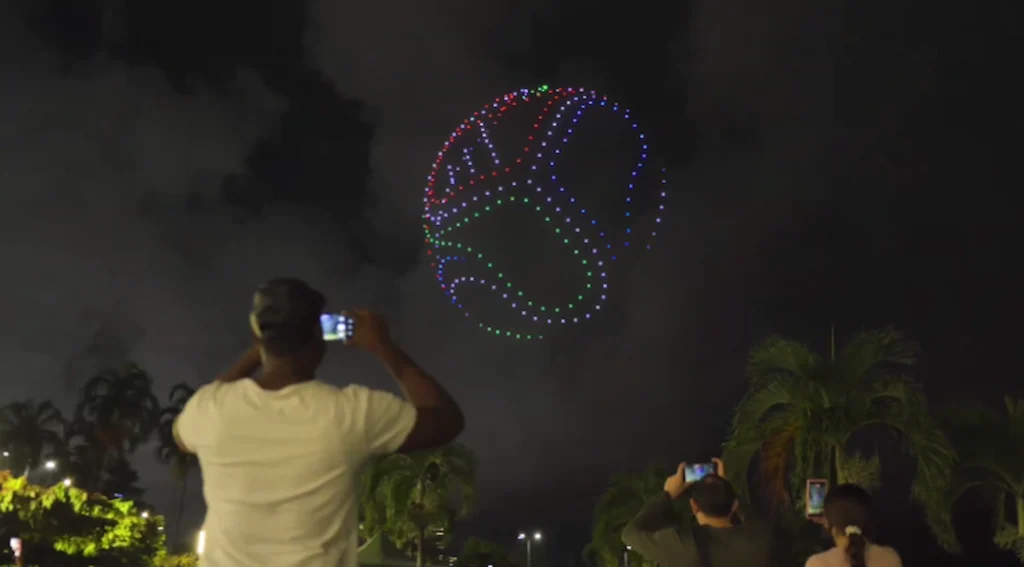 persona tomando fotografía al balón de adidas hecho con drones